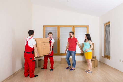 Movers carrying household items through a residential property in Ruislip